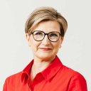 Valkoihoinen nainen punaisessa paidassa.