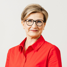 Valkoihoinen nainen punaisessa paidassa.
